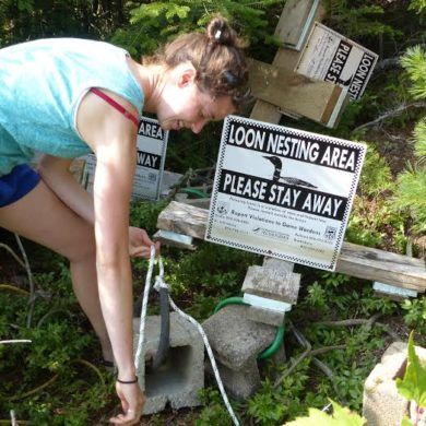 Adding new rope and swivel hooks onto a loon sign buoy. Photo by Eric Hanson.