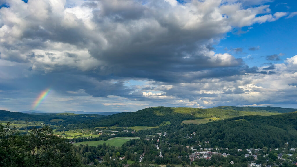 Sunny skies with a rainbow over Woodstock, VT, as seen from Mount Tom.